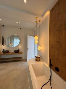 a bathroom with a bath tub and a mirror at Poema Antiparos in Antiparos