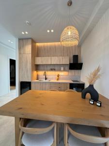 a dining room with a wooden table and a kitchen at Poema Antiparos in Antiparos