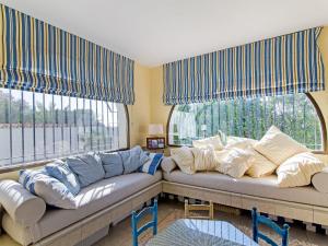 salon z kanapą i dwoma dużymi oknami w obiekcie Superb beachfront villa with guest house 50m opposite w mieście Mijas Costa