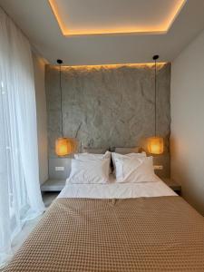 a bedroom with a large bed with two lamps on it at Poema Antiparos in Antiparos