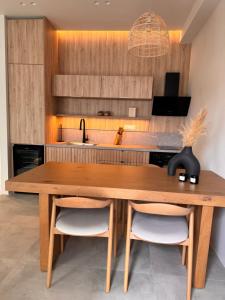 a kitchen with a wooden table and two chairs at Poema Antiparos in Antiparos