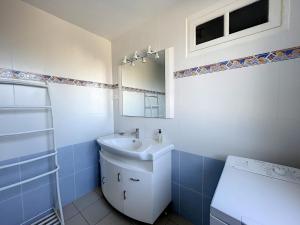 a bathroom with a sink and a mirror at Maison paisible proche de la plage avec jardin et équipements complets - FR-1-361-491 in Carolles +7 photos