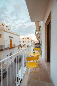 a balcony with a yellow table and chairs on it at La Casa di Vittoria Apartment Sea View - Housea in Polignano a Mare