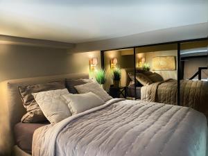una camera da letto con un grande letto bianco e specchi di Black Suite 2 Luxus in Alsternähe ad Amburgo