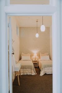 een slaapkamer met 2 bedden en een tafel met een lamp bij Postmasters Apartment Motueka in Motueka