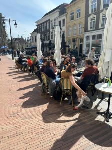 un groupe de personnes assises à table dans un restaurant en plein air dans l'établissement Good Seasons City Centre Hotel Den Bosch, à Bois-le-Duc