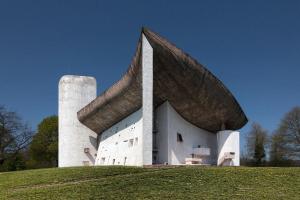 een groot wit gebouw met een toren op een heuvel bij 'Maison des artistes' for up to 20 in Nature Park in Plancher-Bas