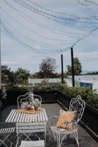 een patio met 2 stoelen, een tafel en een bank bij Postmasters Apartment Motueka in Motueka