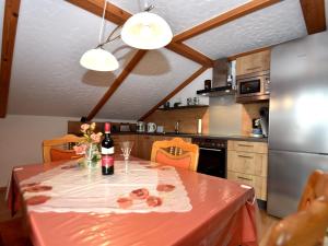a kitchen with a table with a bottle of wine at Scenic Apartment with Balcony Garden Deckchairs Barbecue in Gleißenberg