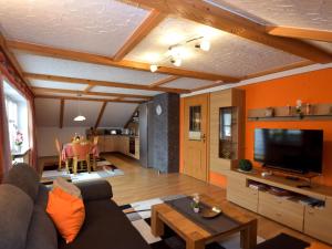 a living room with a couch and a table at Scenic Apartment with Balcony Garden Deckchairs Barbecue in Gleißenberg