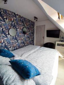 a bedroom with a large bed with blue pillows at Apartament Słoneczny in Mrągowo