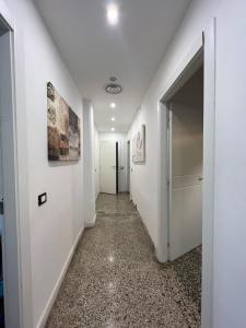 um corredor vazio com paredes brancas e um corredor com portas brancas em Ambra em Génova