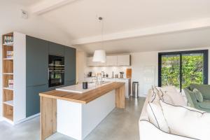 an open kitchen and living room with a counter and chairs at Villa Stendhal - Welkeys in Seignosse