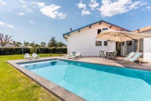 a villa with a swimming pool and a house at Villa Stendhal - Welkeys in Seignosse +11 photos