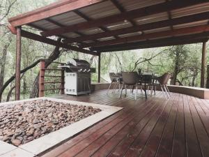 una terrazza con griglia, tavolo e sedie di HUIS ASEM a Marloth Park