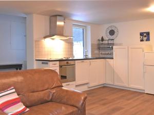 ein Wohnzimmer mit einem Sofa und einer Küche in der Unterkunft Holiday home in ldernTwistetal Oberwaro with sauna in Oberwaroldern