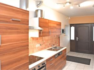a kitchen with wooden cabinets and a sink at Holiday home in ldernTwistetal Oberwaro with sauna in Oberwaroldern