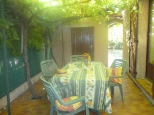 a table and chairs in a room with a table and trees at Maison de l'Horte in Ginestas