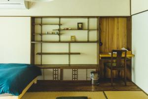 Zimmer mit einem Bett und einem Schreibtisch in der Unterkunft Masukichi 古民家宿ますきち 駐車場無料 in Seto