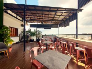 a restaurant with tables and chairs on a balcony at Merchant Hotel in George Town