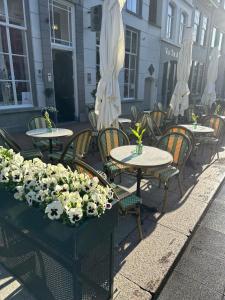 un grupo de mesas y sillas con flores. en Good Seasons City Centre Hotel Den Bosch, en Den Bosch