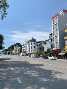 an empty street in a city with buildings and cars at Hotel Me Kong in Ha Long