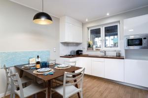 a kitchen with a wooden table and white cabinets at Apartamenty, Domki i Pokoje ze śniadaniem Kajan in Jastrzębia Góra +285 photos