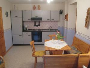 eine Küche mit einem Holztisch und eine Küche mit weißen Schränken in der Unterkunft Charming Apartment in Morbach Germany with Terrace in Thalfang