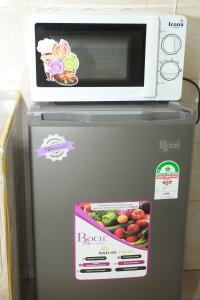 eine Mikrowelle auf einem Kühlschrank in der Unterkunft Zedek Furnished Apartment 102 in Nairobi