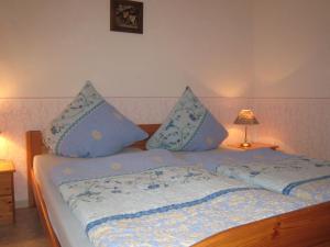 a bed with blue pillows on top of it at Charming Apartment in Morbach Germany with Terrace in Thalfang