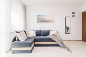 uma sala de estar com um sofá azul num quarto em Apartamenty - Sztutowo Zalewowa em Sztutowo