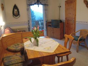 ein Wohnzimmer mit einem Tisch und einer Blumenvase darauf in der Unterkunft Charming Apartment in Morbach Germany with Terrace in Thalfang