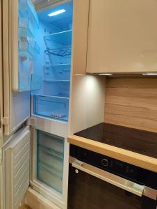 a kitchen with an empty refrigerator with its door open at Versailles Direct Royal 4 pers in Versailles