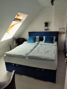 a bedroom with a blue bed in a attic at Apartament Słoneczny in Mrągowo
