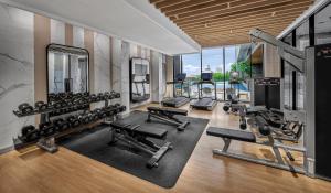 a gym with several treadmills and weights at Hyatt Place Makassar in Makassar