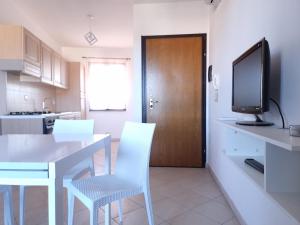 a kitchen with a table and chairs and a television at Casa Vecchio Mulino in Budoni +9 photos