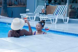 a woman in a swimming pool holding a glass of wine at 129inHarties Lodge and SPA in Hartbeespoort