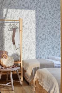 a room with a bed and a chair and wallpaper at W Brzozowym Gaju Lubiatowo in Lubiatowo