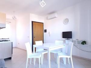 a white dining room with a white table and chairs at Casa Vecchio Mulino in Budoni