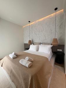 a bedroom with a large bed with towels on it at Poema Antiparos in Antiparos