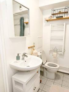 a white bathroom with a sink and a toilet at « Le Cosy » Cergy le Haut RER A in Cergy