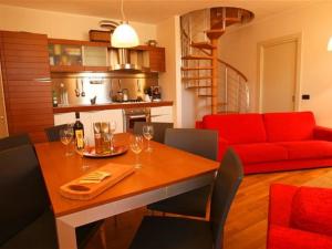 ein Wohnzimmer mit einem Tisch und einem roten Sofa in der Unterkunft La Piazza Menaggio in Menaggio