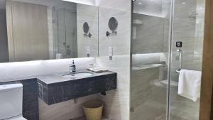 bagno con lavandino e doccia in vetro di Mito Serviced Apartment a Canton