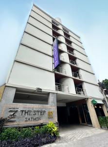 un bâtiment avec un panneau devant lui dans l'établissement The Step Sathon, à Bangkok