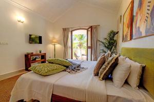 Кровать или кровати в номере Aguada Anchorage - The Villa Resort, Candolim
