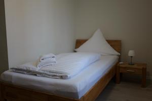 ein Bett mit weißer Bettwäsche und Handtüchern darauf in der Unterkunft Hotel Milano in Hildesheim