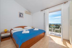 a bedroom with a bed and a large window at Rooms Olive and Sea in Tučepi