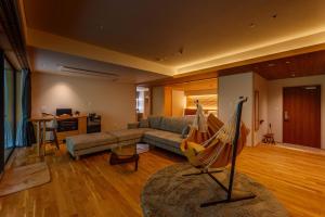 a living room with a couch and a hammock at Sakunami Onsen Yuzukushi Salon Ichinobo in Sendai