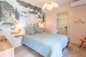 Chambres d'hôtes Le Studio Bordelais avec bain nordique في ميرينياك: غرفة نوم بسرير ازرق مع لوحة على الحائط