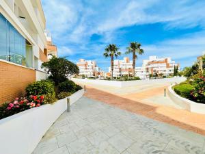 einen Gehweg in einer Stadt mit Gebäuden und Palmen in der Unterkunft Attractive apartment in Roquetas de Mar with terrace in Roquetas de Mar